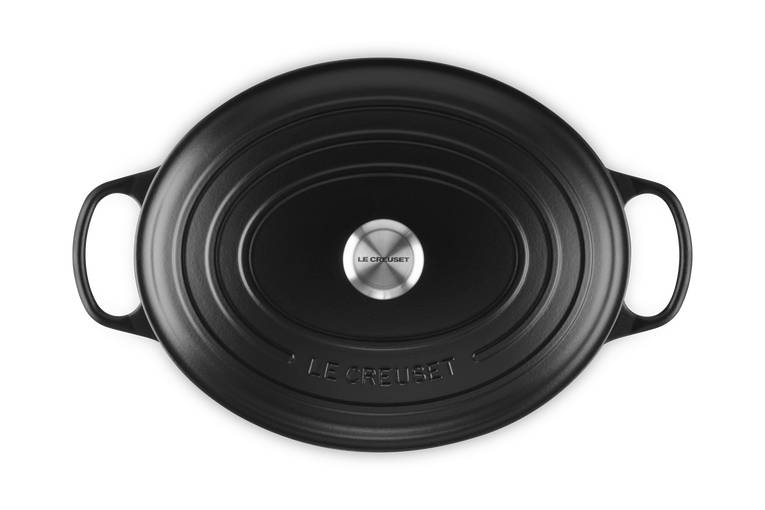 Schwarzes ovales Le Creuset Gusseisen-Bräter oder Schmortopf mit zwei Seitengriffen, von oben auf weißem Hintergrund dargestellt.