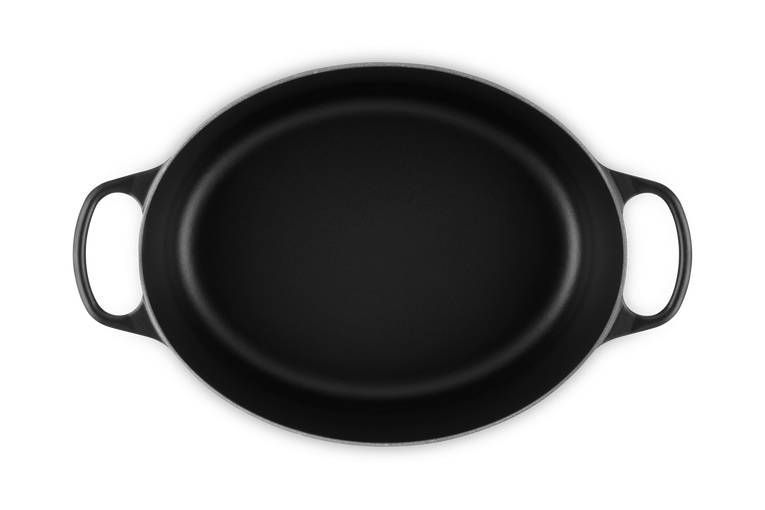 Schwarze ovale Gusseisenpfanne mit zwei Schleifengriffen, von oben auf weißem Hintergrund dargestellt.