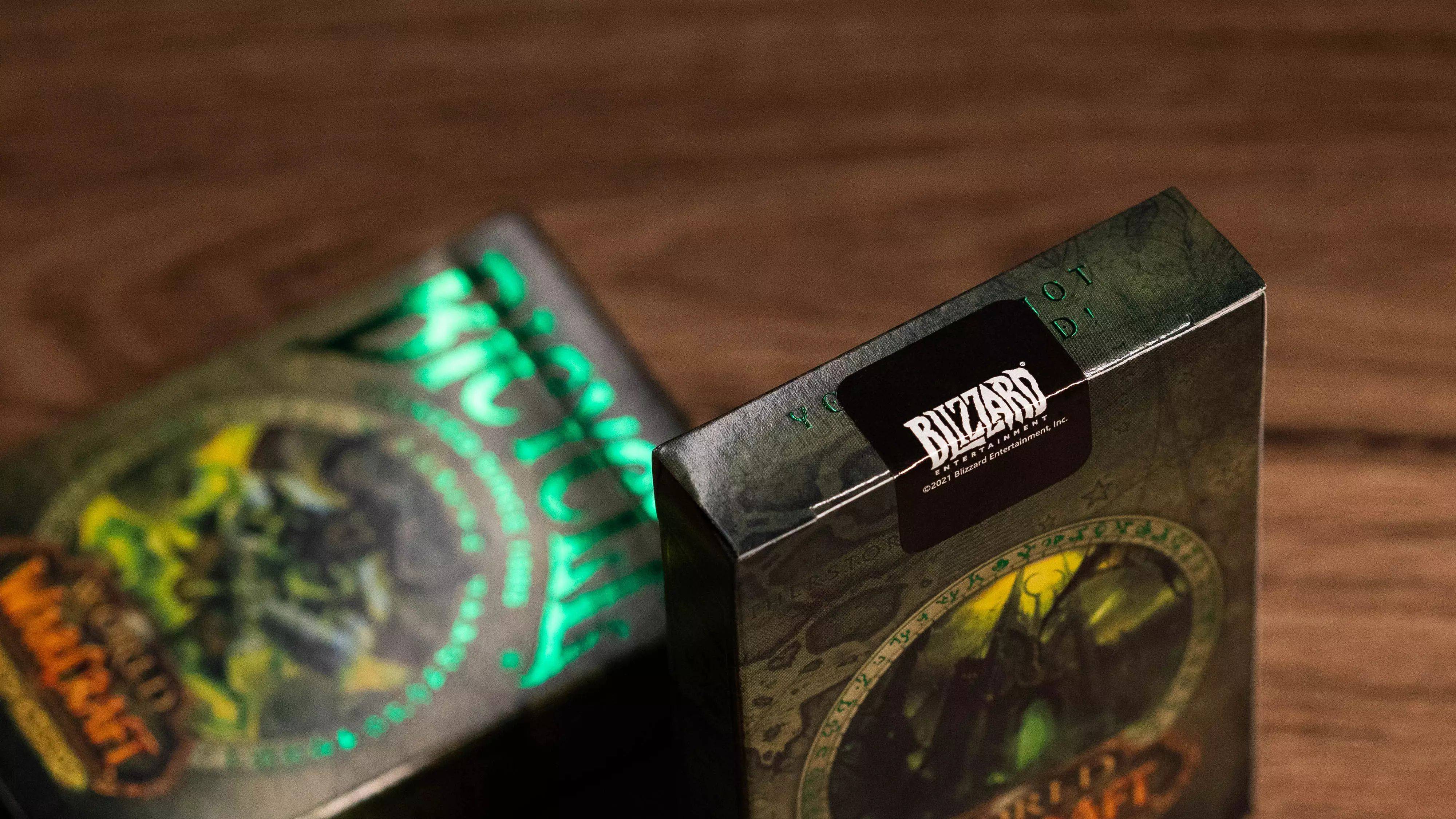 Eine BlizzCon-Sammelbox mit einem grün leuchtenden kreisförmigen Design und düsterer Fantasy-Artwork sitzt auf einem Holztisch.