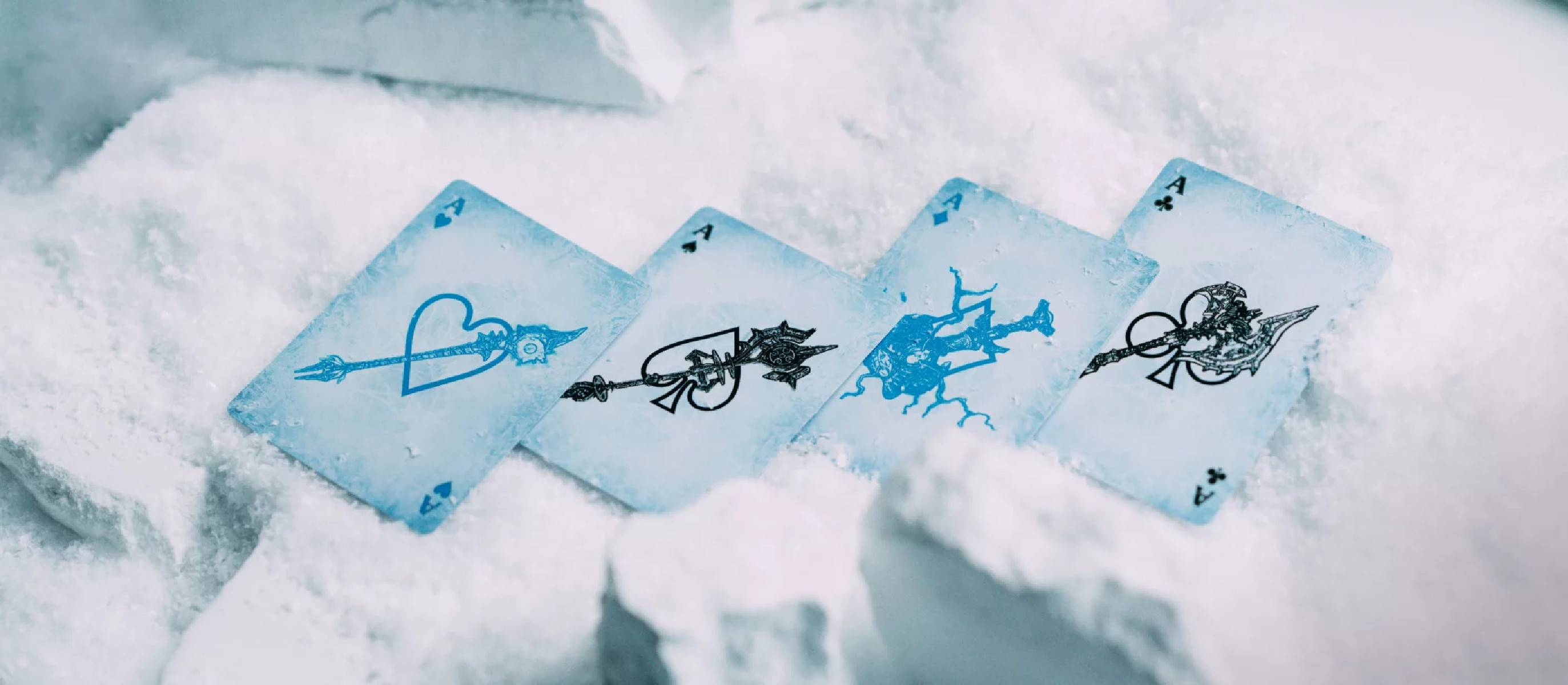 Vier Spielkarten in verschneiten Wolken zeigen einfache Strichzeichnungen von Waffen und Symbolen, darunter ein Herz und eine schwertähnliche Figur.