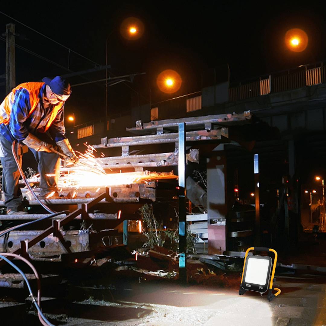 Arbeiter in reflektierender Weste und Helm schneidet Metall mit fliegenden Funken an einem düsteren Industriegelände, beleuchtet durch ein tragbares Arbeitsleuchte.