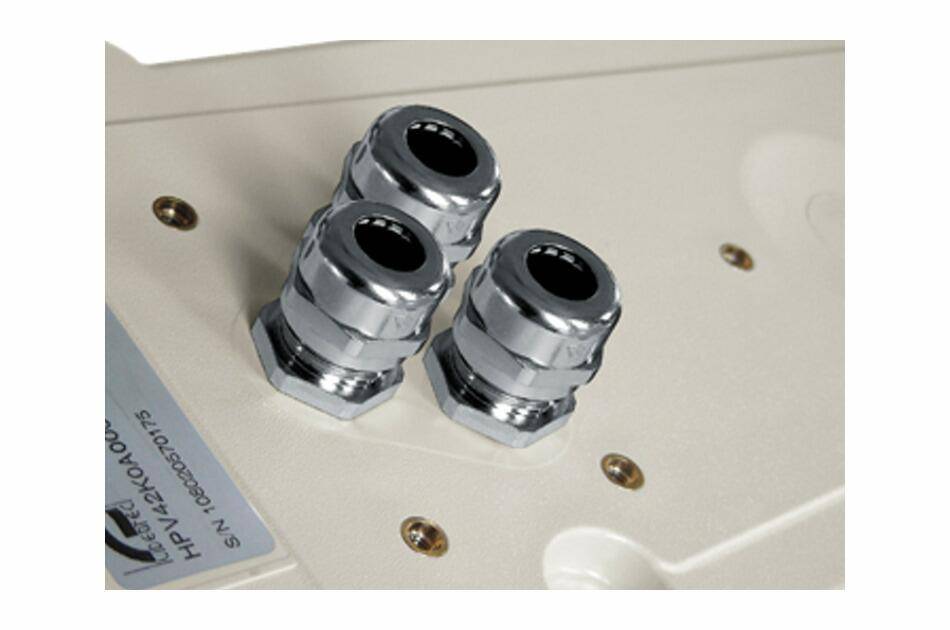 Drei Chromkabelverbinder auf einem beigen Elektropanel montiert.