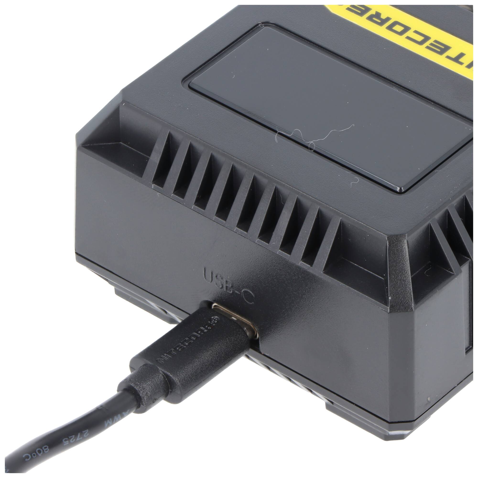 Schwarzes elektronisches Gerät mit einem USB-C-Kabel, das in den vorderen Anschluss auf weißem Hintergrund gesteckt ist.