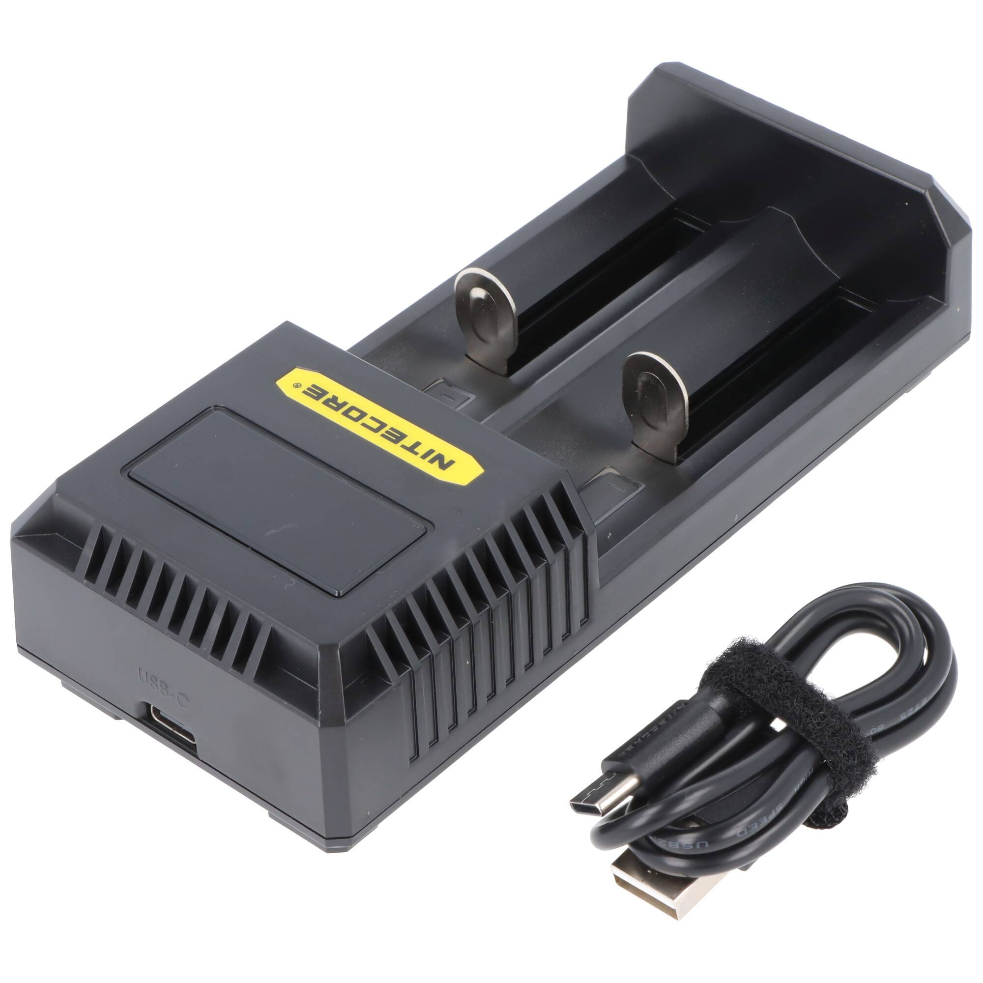 Schwarzes Nitecore-Ladegerät mit zwei Federschlitzen und USB-Kabel auf weißem Hintergrund.