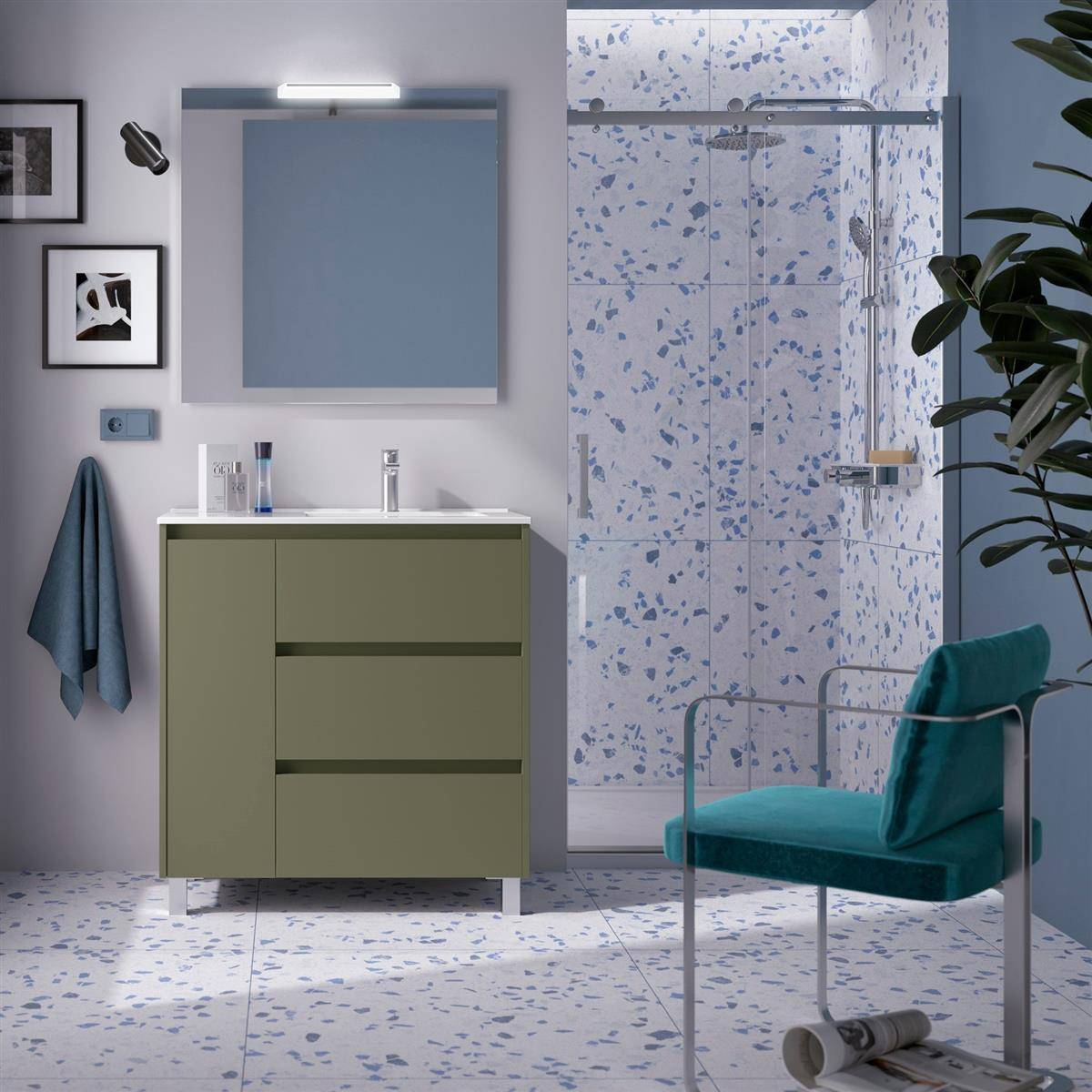 Modernes Badezimmer mit olivfarbenem Waschtisch und Spiegel, Duschkabine, türkisem Stuhl, Wandkunst und gefliestem Boden und Wänden mit Sprenkeleffekt.