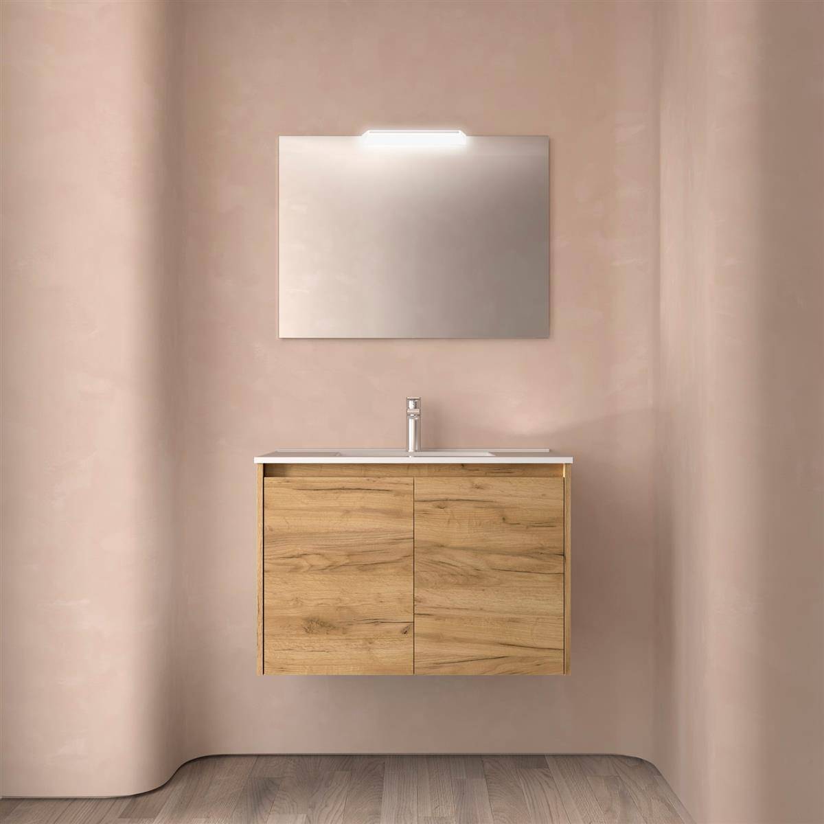 Ein minimalistisches Badezimmer-Waschtisch mit einem schwebendem Holzschrank, Waschbecken und Wandspiegel an einer hellrosa Wand.