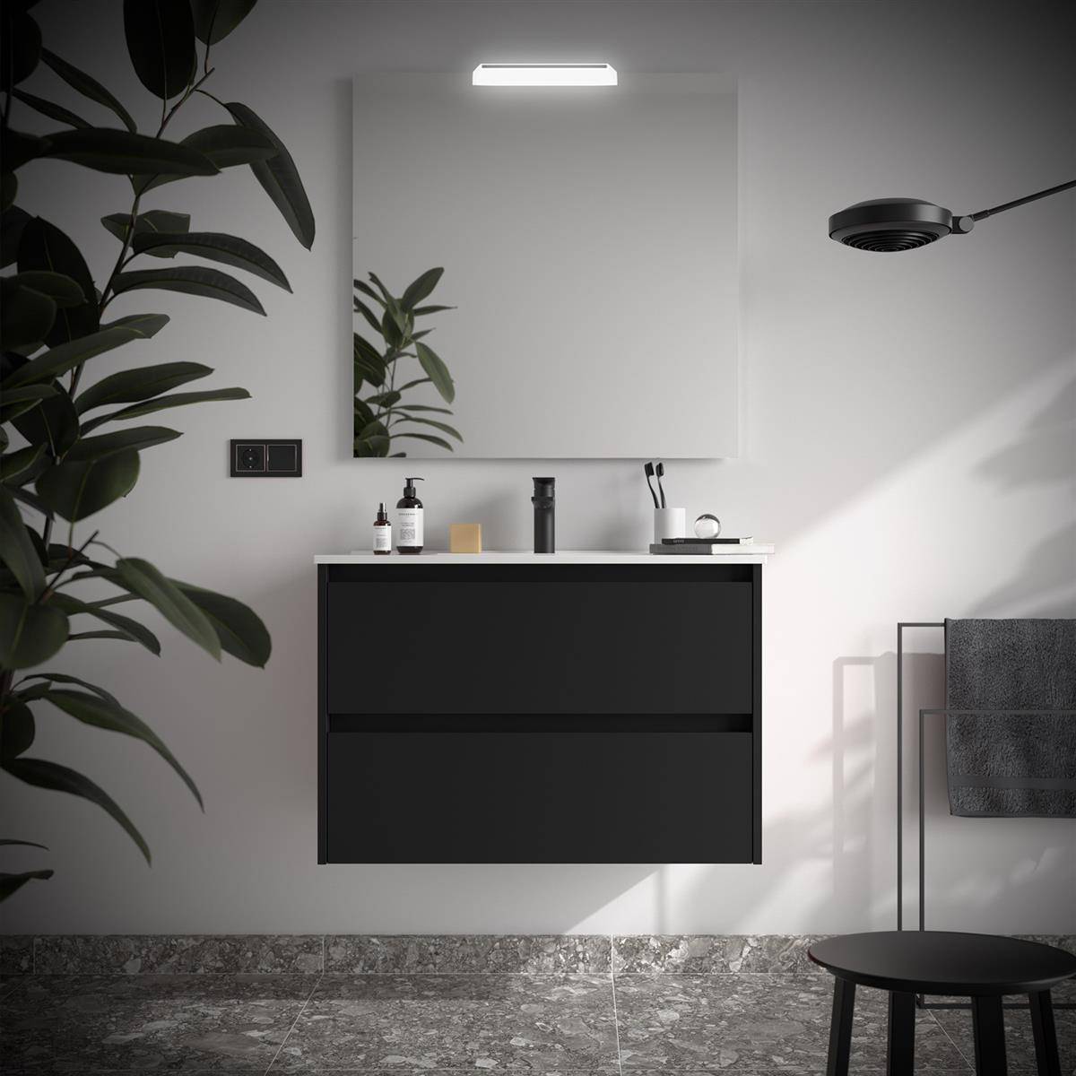 Minimales modernes Badezimmer mit schwarzem schwebendem Waschtisch, großem Spiegel, Wandleuchte, Handtuchhalter und einer blättrigen Pflanze im Vordergrund.