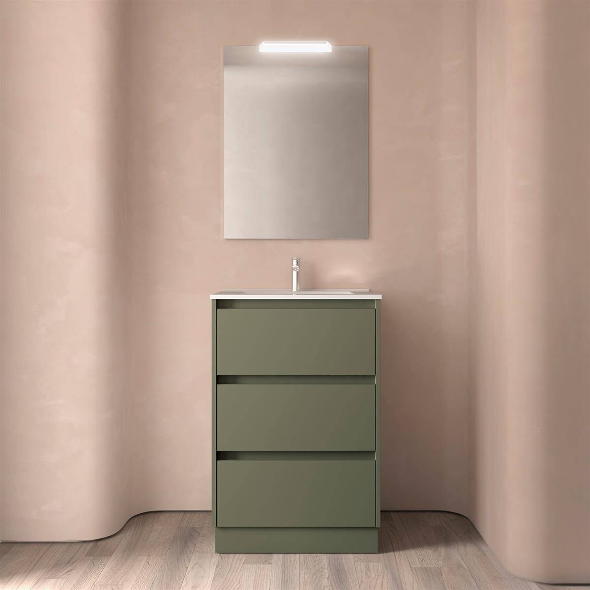 Modernes Badezimmer-Waschtisch mit olivgrünen Schubladen, weißem Waschbecken, Spiegel und Deckenleuchte an blushfarbenen Wänden und Holzoptik-Boden.