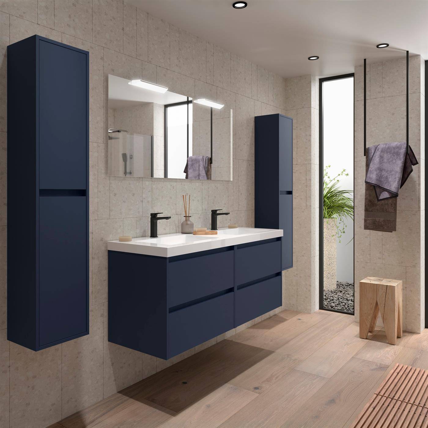 Modernes Badezimmerinterieur mit schwebendem marineblauem Waschtisch, Doppelwaschbecken, großem Spiegel, hohen Schränken, Handtuchhaken und einer kleinen Pflanze neben einer Glastür.