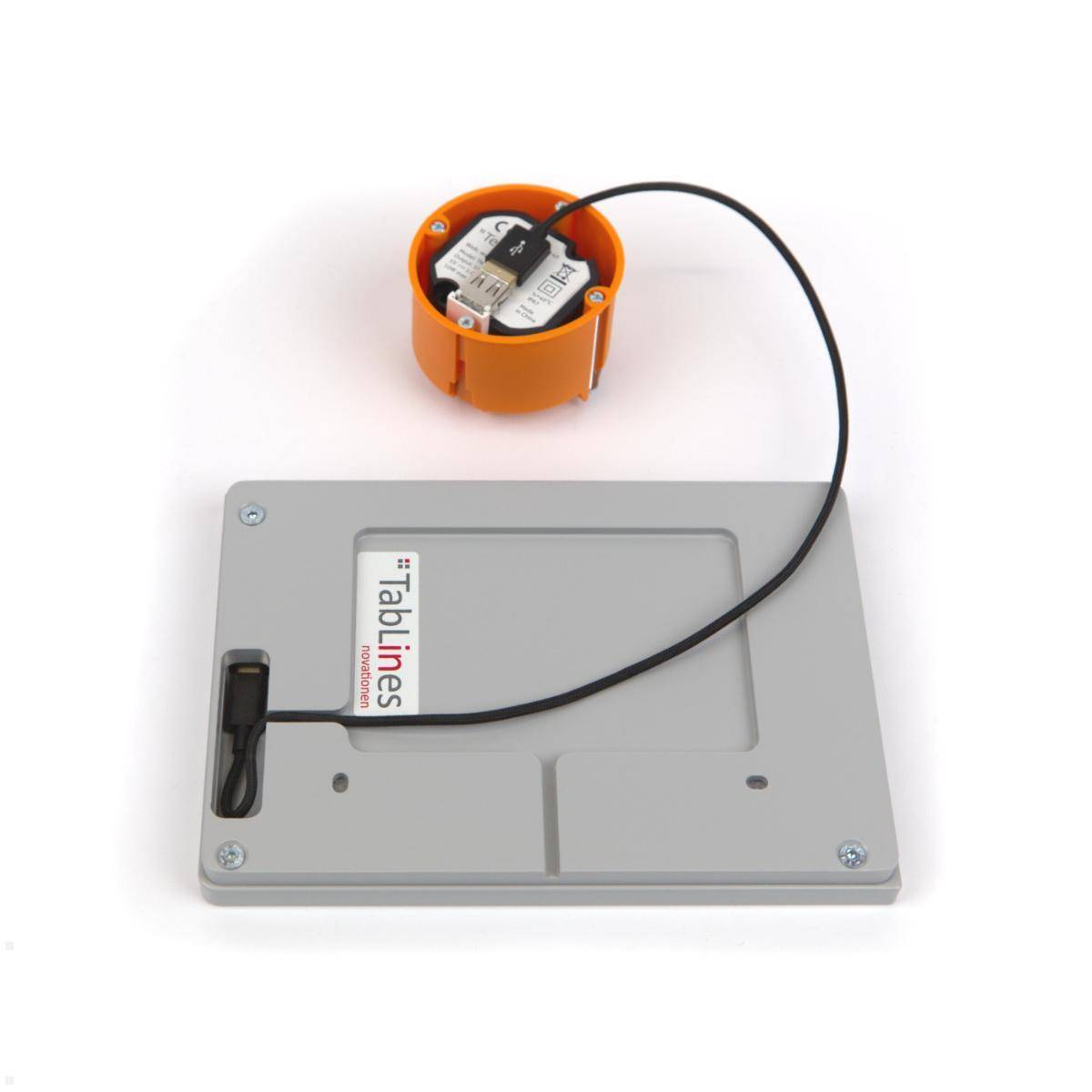 Ein Montageset zur Installation von wandmontierter Tabletkapseln, bestehend aus einer Metallrückplatte, Verkabelung und einer orangefarbenen Anschlussbox.