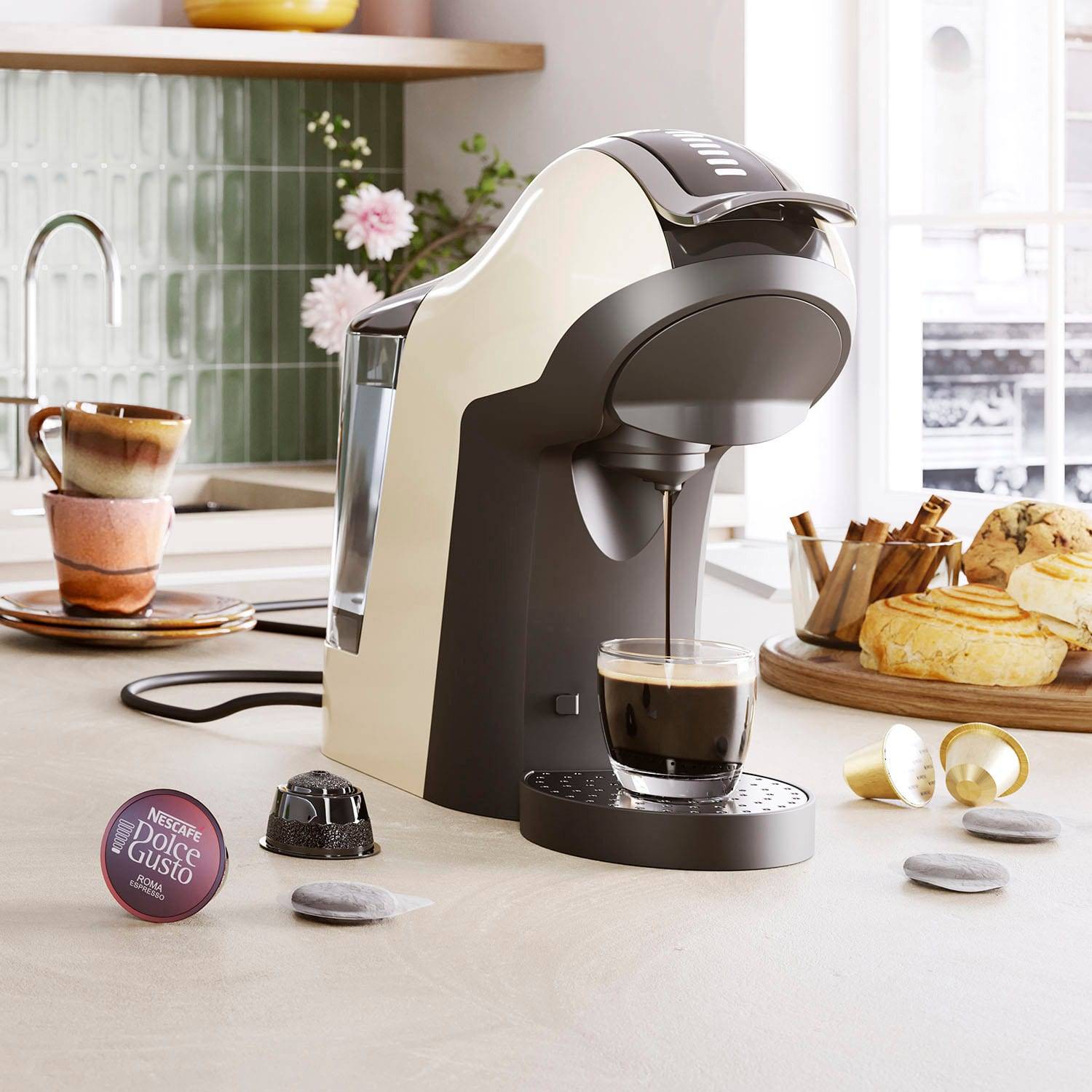 Eine moderne Kaffeemaschine braut Espresso in eine Glastasse auf einer Küchentheke, in deren Nähe Croissants, Obst und eine Tasse stehen.