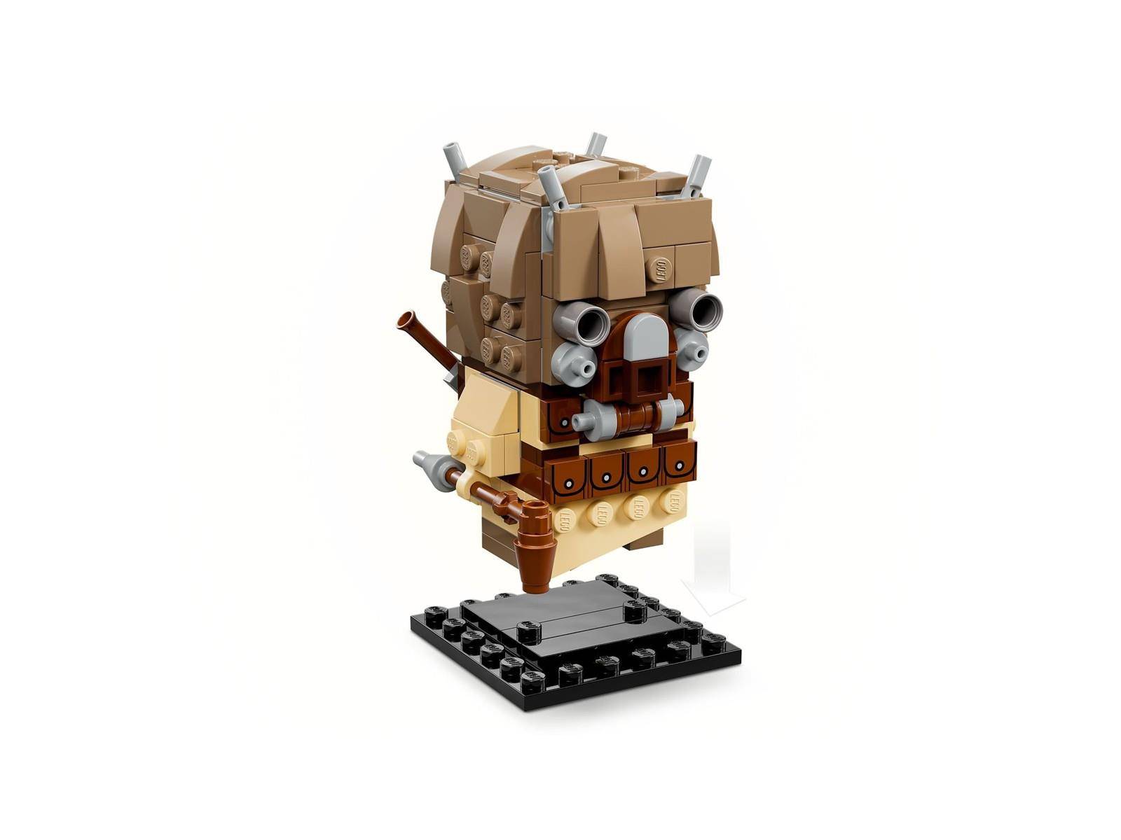 LEGO-ähnlicher schwebender beige und brauner Roboterkopf mit mechanischen Augen und Rohren auf einem schwarzen Ausstellungsständer.