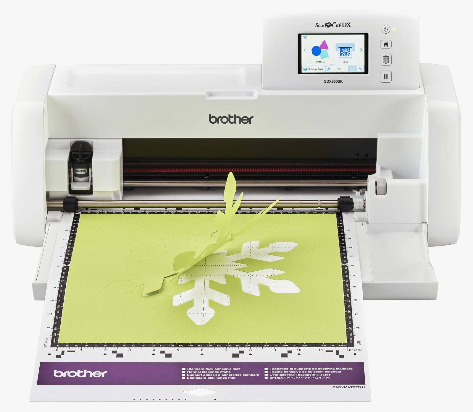 Bruder ScanNCut DX Schneidemaschine schneidet ein Schneeflocken-Design aus grünem Material auf einer Matte.