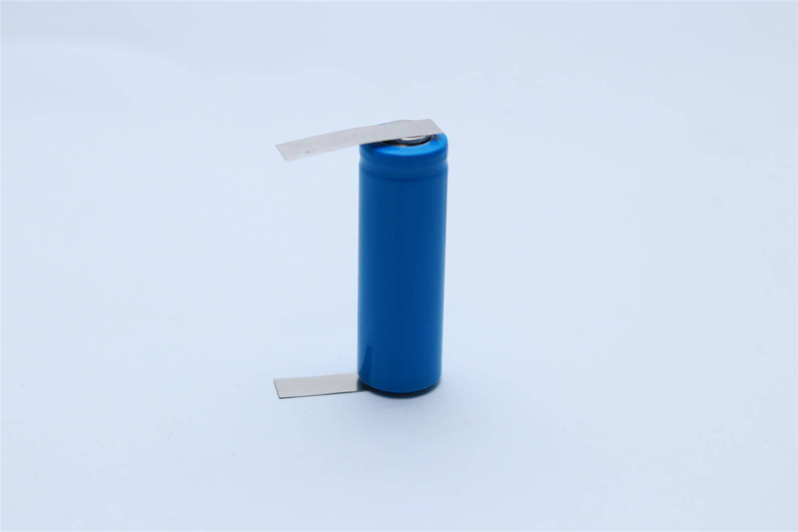 Eine blaue zylindrische Batterie mit Metallkontakten an beiden Enden, vor einem einfarbigen weißen Hintergrund.