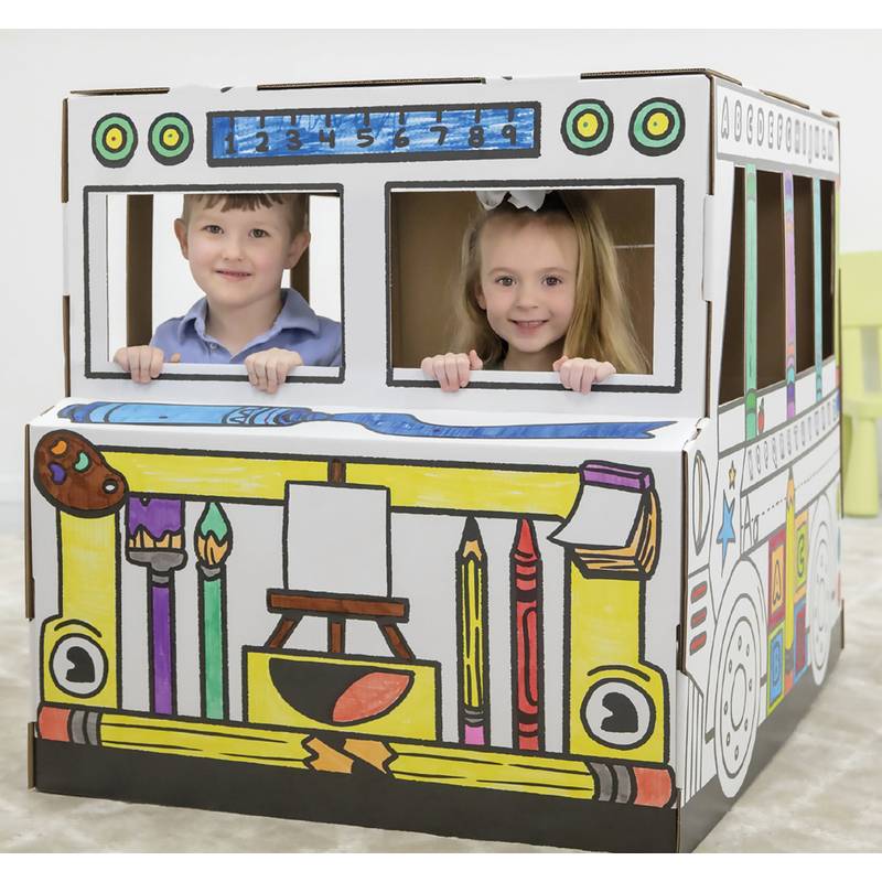 Zwei Kinder lächeln und spielen in einem bunten Kartonbus, der mit Künstlerbedarf wie Pinseln und Buntstiften geschmückt ist und ein kreatives Thema andeutet.