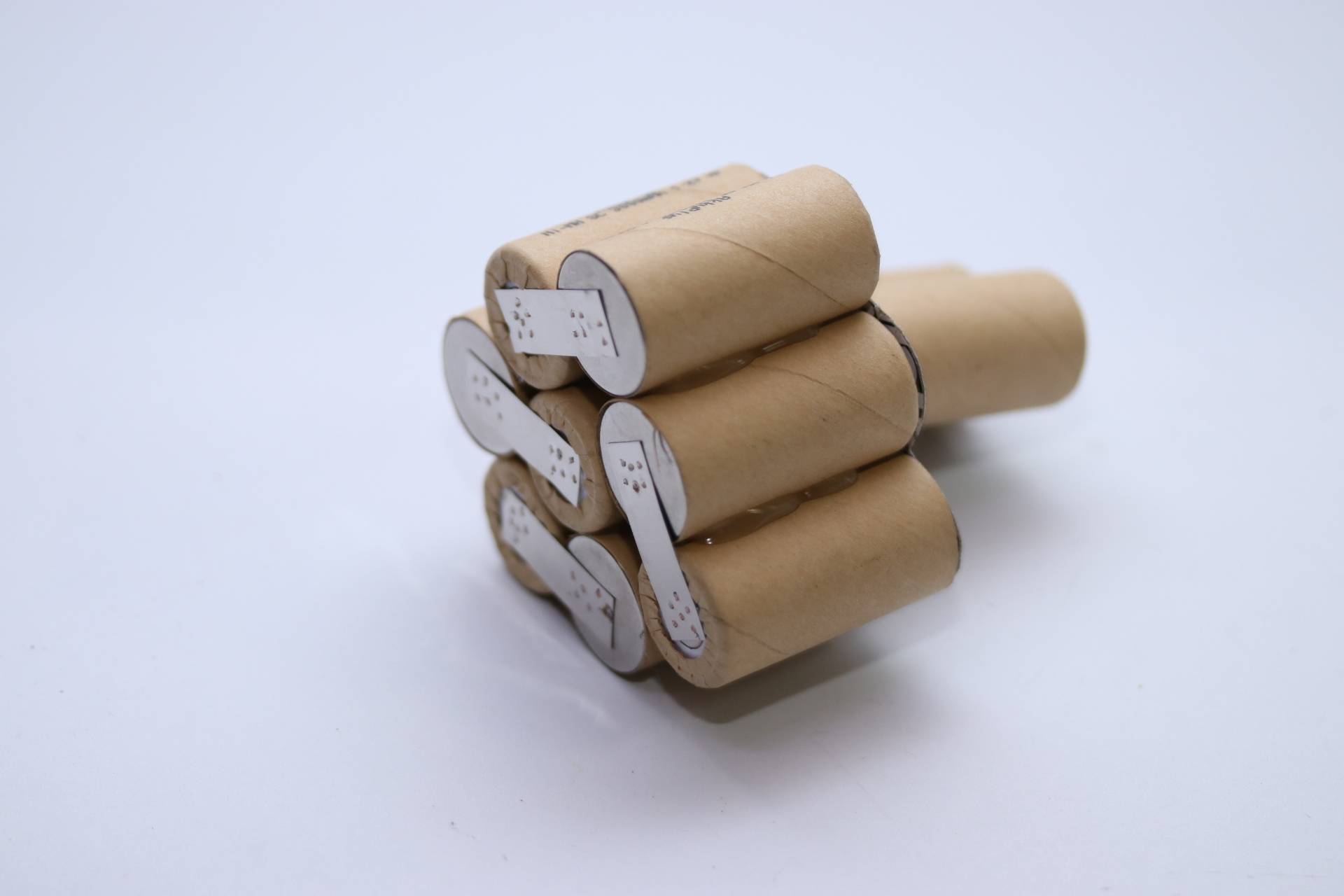 Ein Bündel aus aufgerolltem braunem Papier, das zusammen gesichert ist und einem Cluster ähnelt, wobei jedes Stück ein weißes Etikett mit schwarzem Text oder Markierungen aufweist.