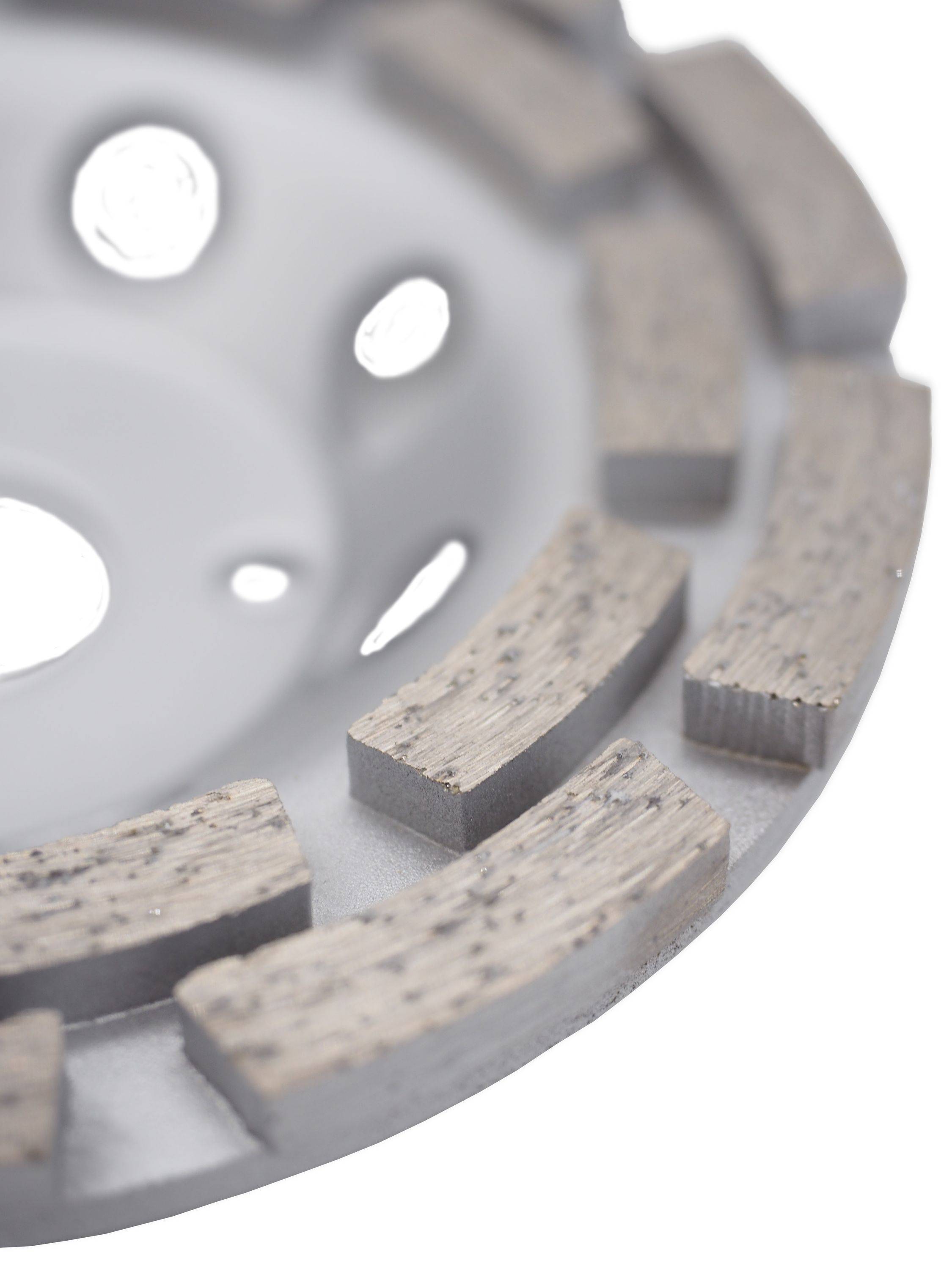 Nahaufnahme einer gebohrten Metallbremsscheibe mit segmentierten Bremsbelägen oder Reibungsblöcken um den Rand herum.