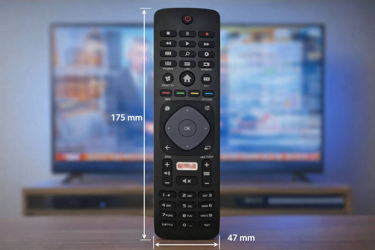 Fernbedienung mit Tasten für Fernseher und andere Geräte, Abmessungen 175 mm x 47 mm. Fernsehbildschirm im Hintergrund sichtbar.