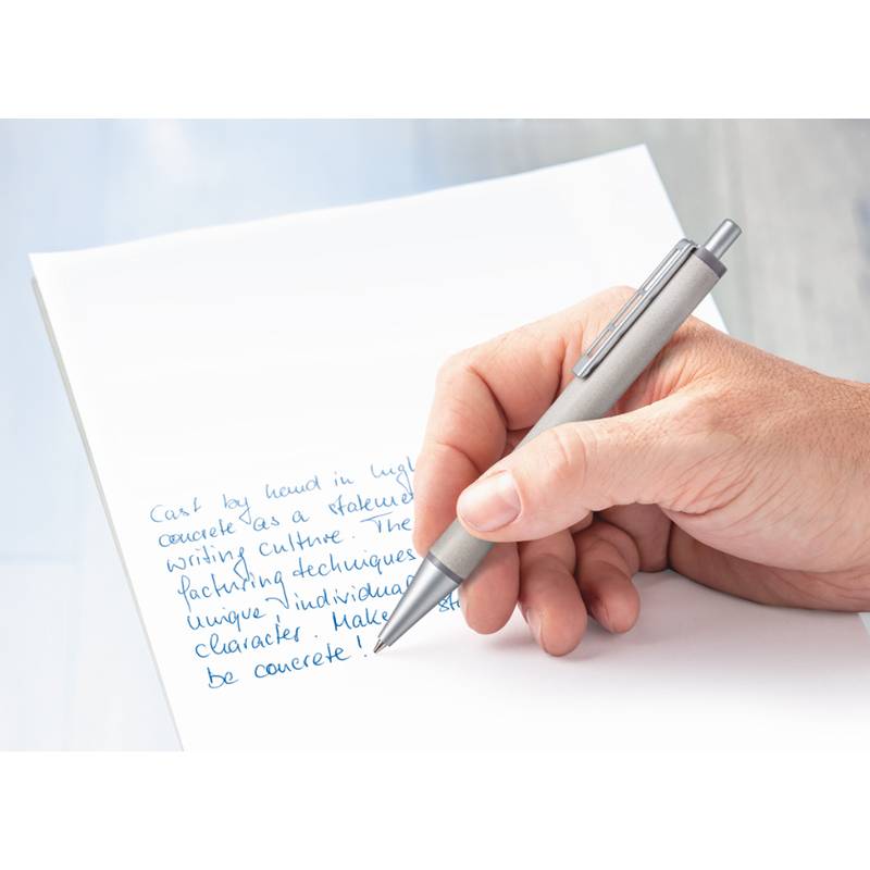 Eine Hand, die einen silbernen Stift hält, schreibt blauen Text auf weißem Papier und konzentriert sich dabei aufs Notieren oder Schreiben.