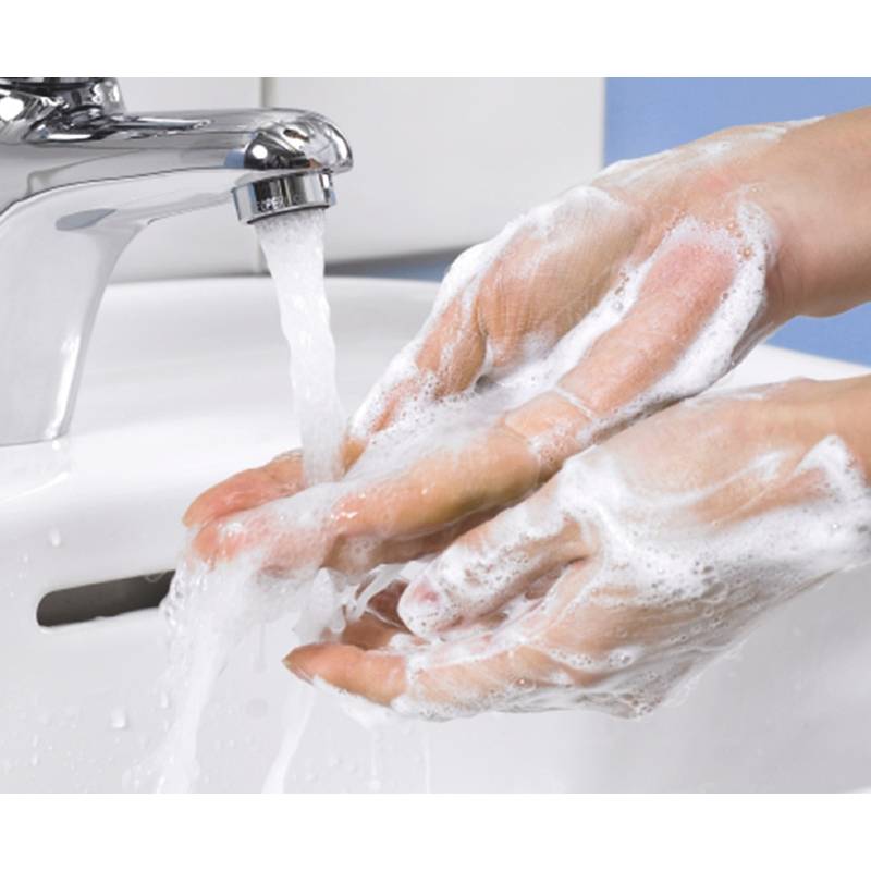Hände, die unter einem Wasserhahn mit Seife gewaschen werden, wobei die Bedeutung von Hygiene und Sauberkeit betont wird.