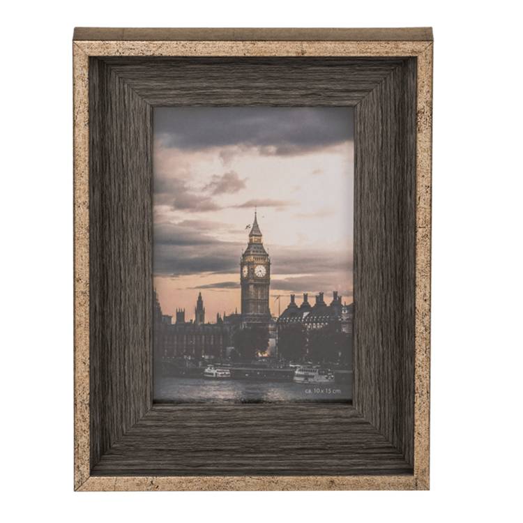 Ein gerahmtes Foto zeigt eine malerische Aussicht auf Big Ben und die Houses of Parliament bei Sonnenuntergang, mit einem bewölkten Himmel und Booten auf der Themse.