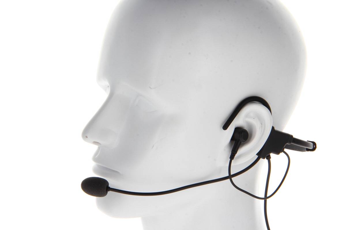 Ein Schaufensterkopf präsentiert ein schwarzes Headset mit Mikrofon und zeigt dessen Passform und Positionierung am Ohr und am Mund.