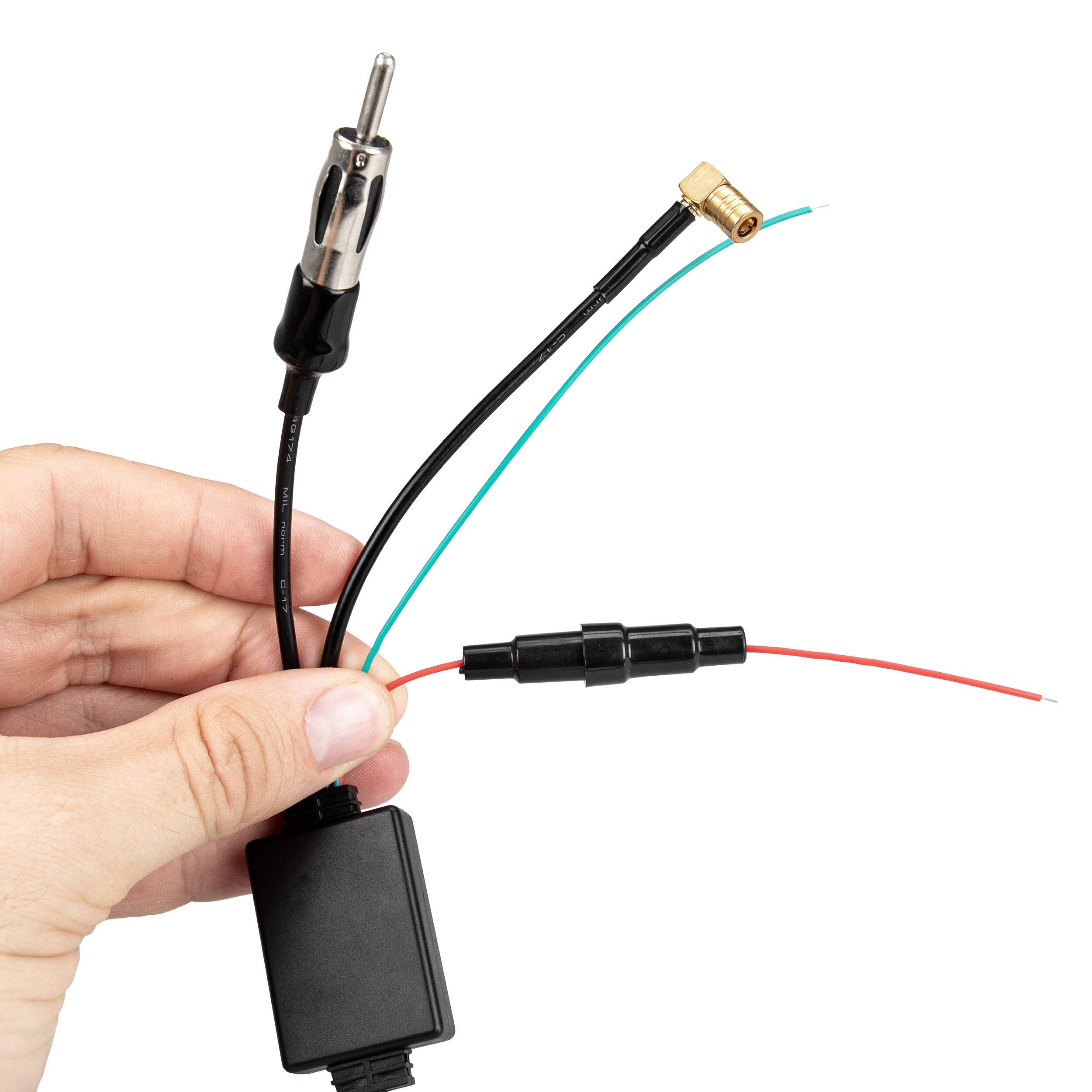 Hand, die ein Automobilradio-Antennenenadapterkabel mit Stecker und Buchse vor weißem Hintergrund hält.