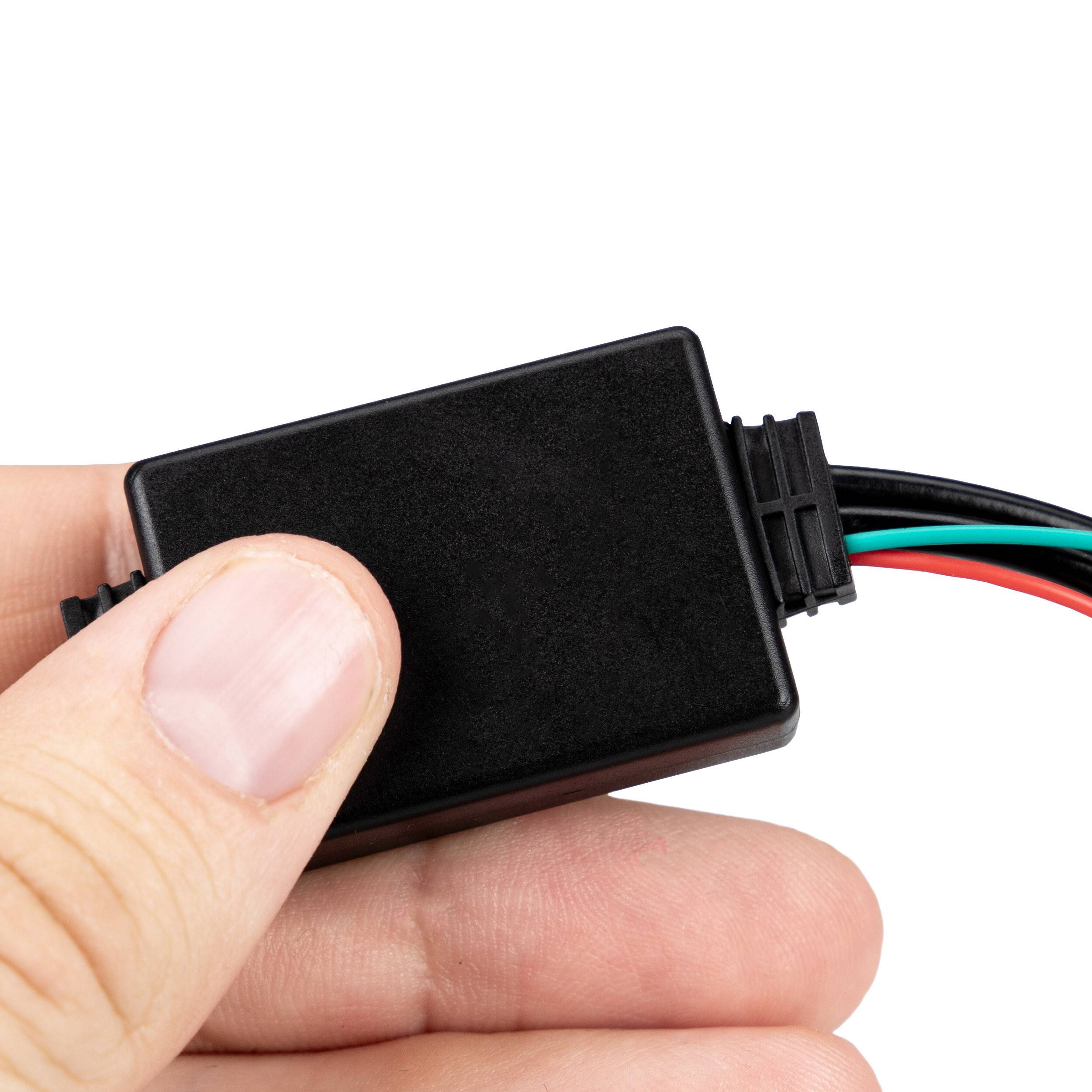 Hand, die ein kleines schwarzes elektronisches Modul mit drei angeschlossenen Drähten auf weißem Hintergrund hält.