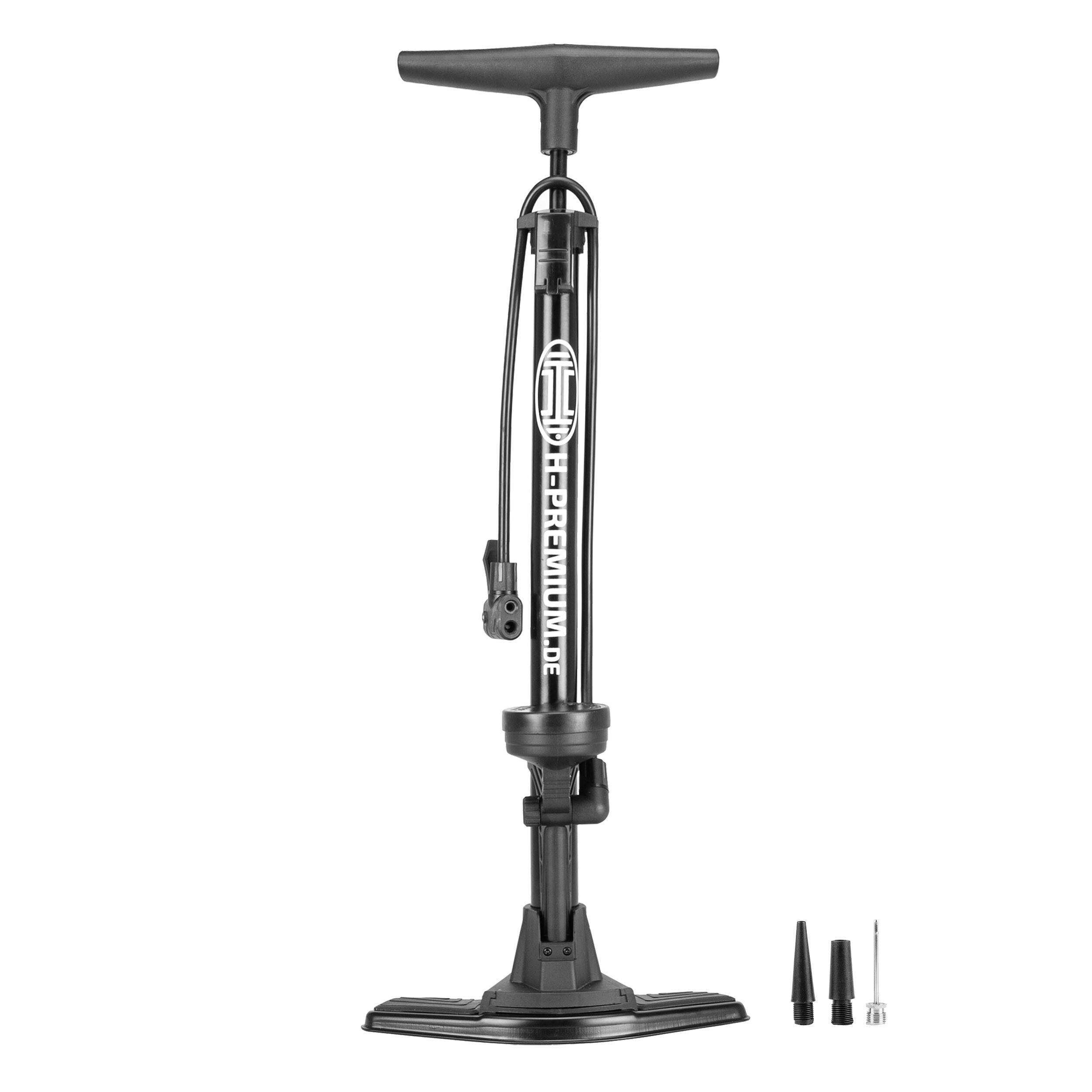 Eine schwarze manuelle Fahrradpumpe mit Manometer, aufrecht stehend. Sie enthält drei Düsenaufsätze daneben: einen konischen, einen spitzen und einen Nadeltyp.