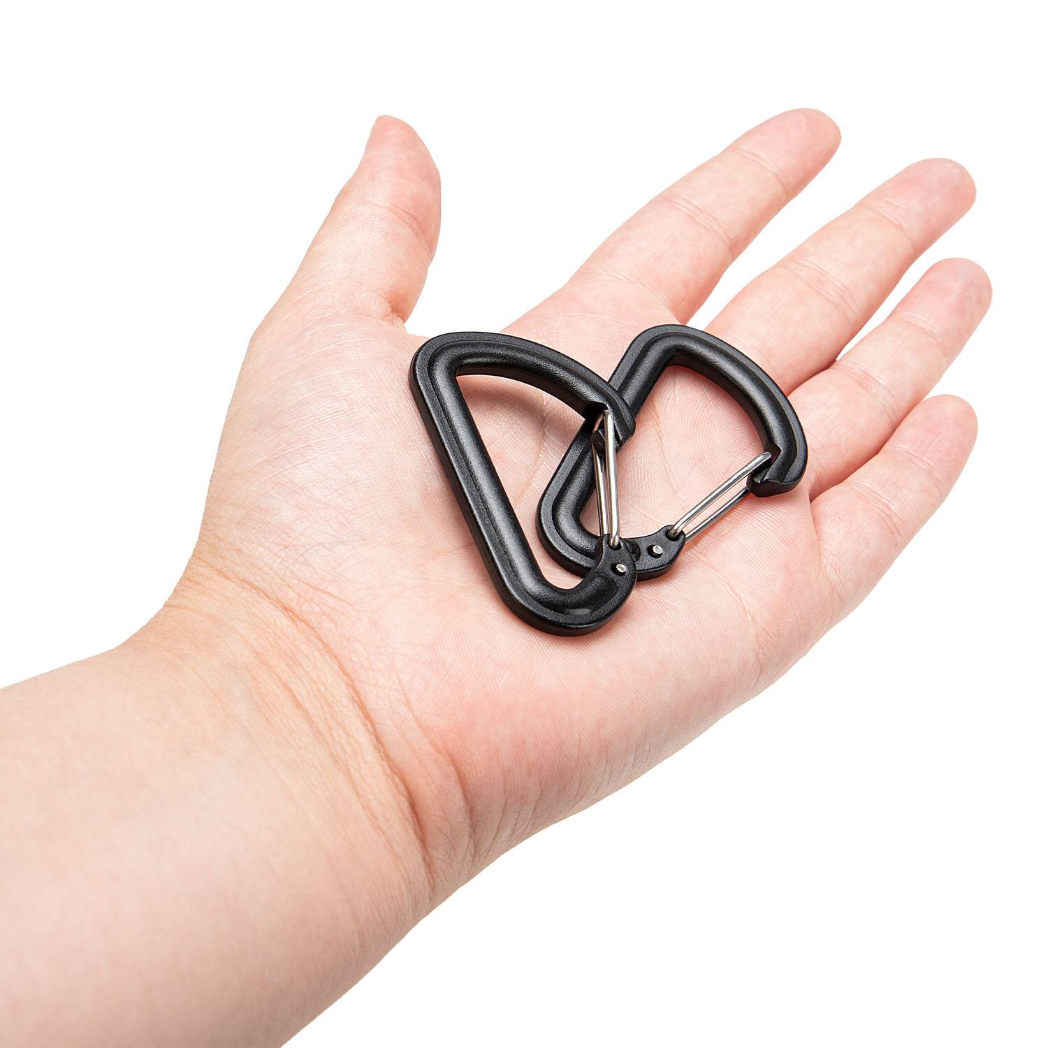 Eine Hand hält zwei kleine, schwarze D-förmige Karabiner und zeigt ihre Größe und ihr Design.