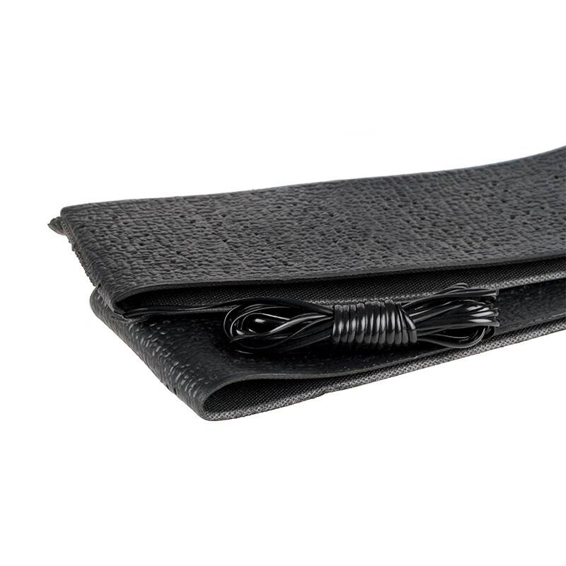 Eine aufgerollte schwarze Yogamatte mit einem schwarzen Ladekabel ordentlich darauf platziert.
