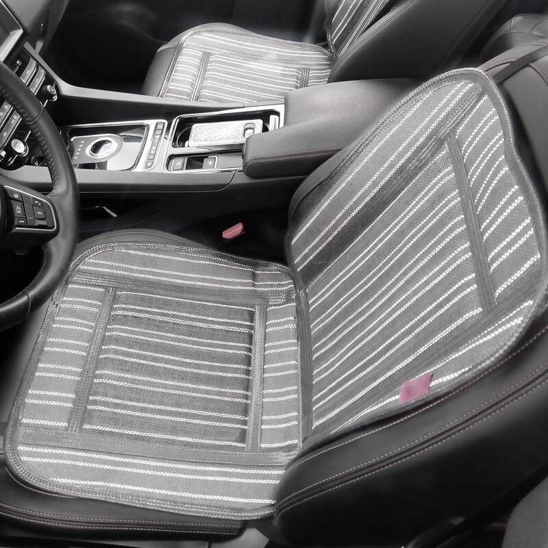 Autoinnenraum mit zwei schwarz-grau gestreiften Sitzbezügen, sichtbaren Armaturenbrett-Kontrollen und mittlerer Konsole, die ein modernes Design zeigt.