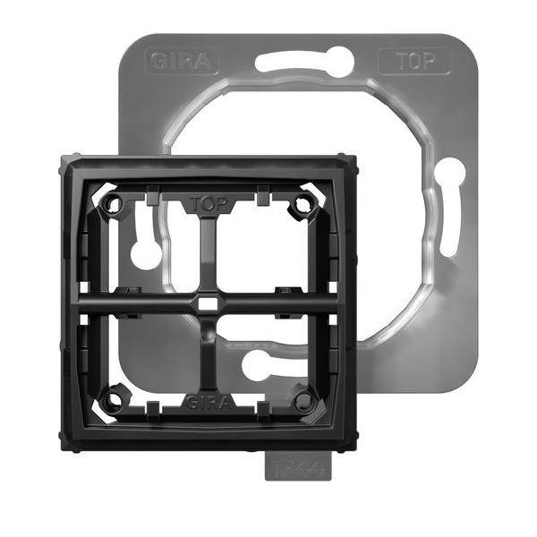 Elektrisches Geräterahmen und Montageplatte mit Beschriftung 'Gira' und 'Top', für Wandmontage konzipiert, Struktur und Schraubpositionen dargestellt.