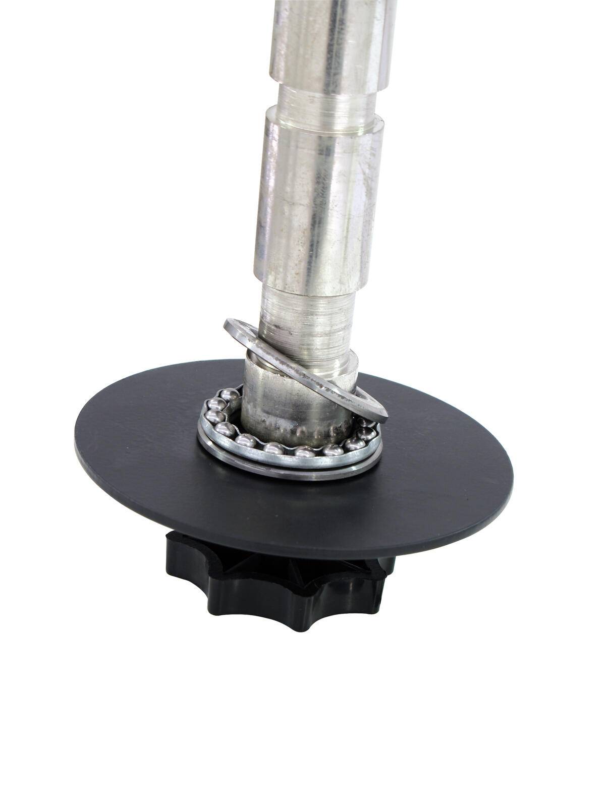 Eine Nahaufnahme eines Metallpfahls mit einer zahnradähnlichen Komponente und runder Basis, möglicherweise Teil eines mechanischen oder industriellen Werkzeugs oder Geräts.