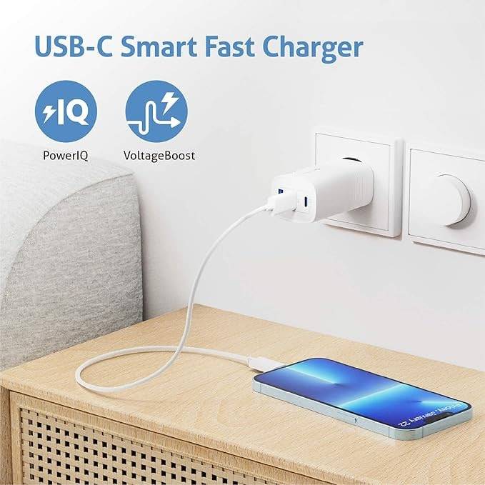 USB-C-Ladegerät eingesteckt, ein Smartphone auf einer Holzoberfläche ladend. Icons demonstrieren die Funktionen 'PowerIQ' und 'VoltageBoost'.