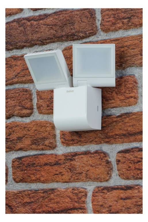 Wandmontierte Außen-Doppel-LED-Leuchten mit weißem Gehäuse an einer Ziegelwand, positioniert für anpassbare Beleuchtungsrichtungen.