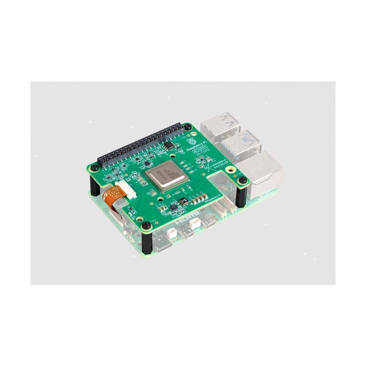 Eine kleine grüne Leiterplatte mit einem metallischen Chip in der Mitte, umgeben von verschiedenen elektronischen Bauteilen und Anschlüssen.