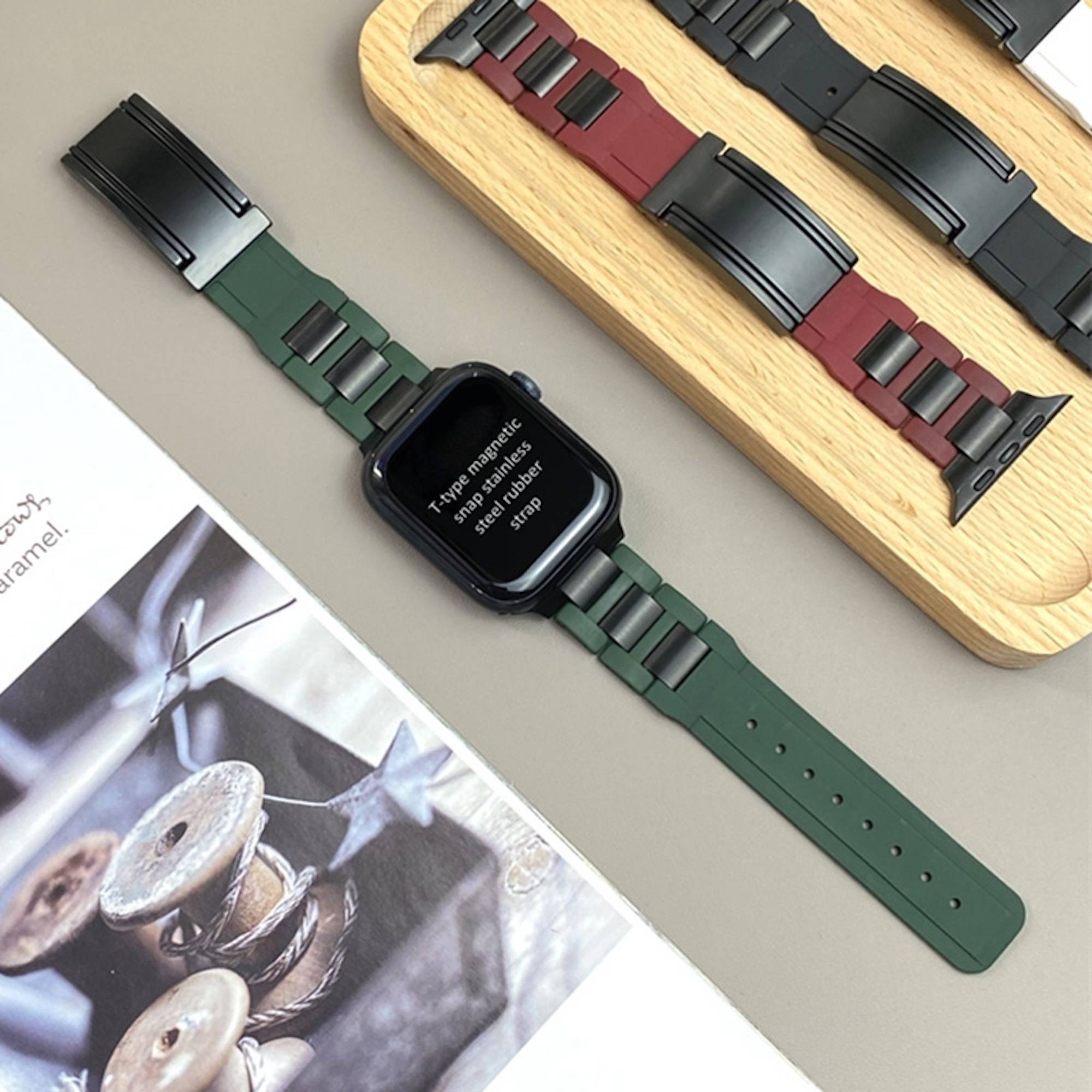 Smartwatch mit grünem Armband auf einer Tischplatte neben einer Musterkarte mit Ersatzbändern, die eine Riemenreinigung zur Schau stellt.