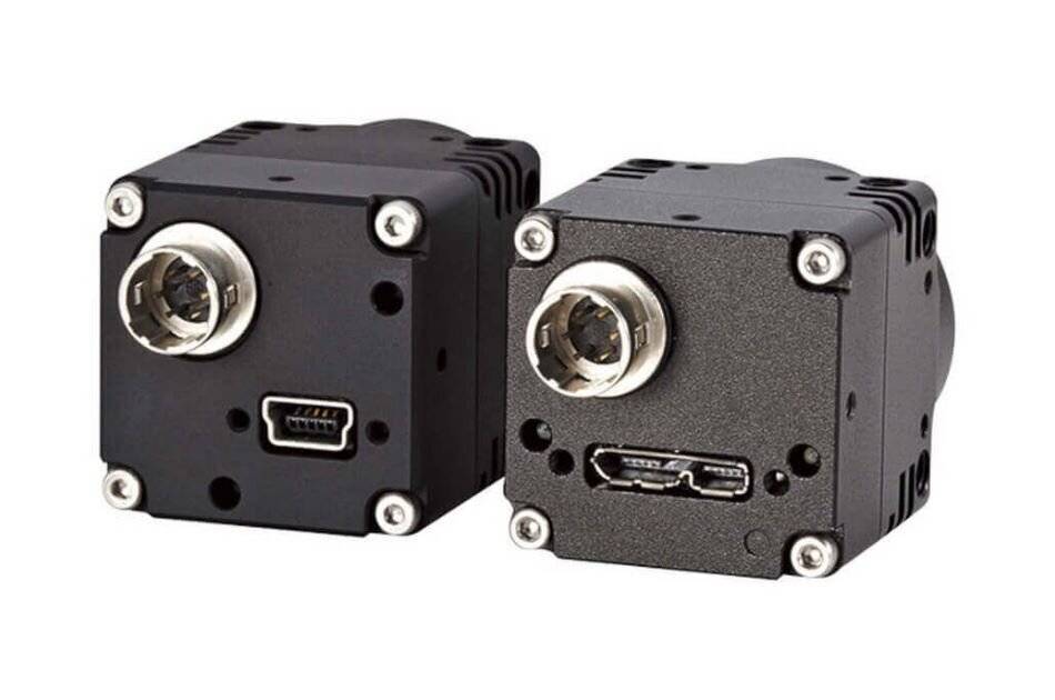 Zwei industrielle Kameramodule mit Metallgehäusen, die jeweils Objektivaufnahmen und verschiedene Anschlüsse für Konnektivität aufweisen.