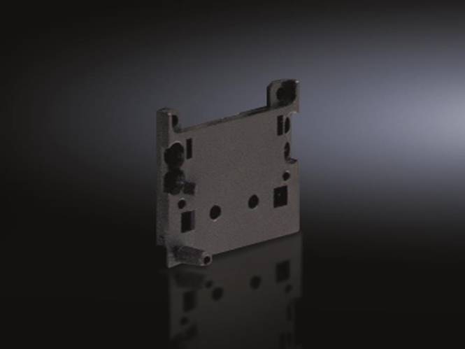 Ein rechteckiges, flaches schwarzes Metallstück mit Löchern und Ausschnitten, möglicherweise eine Montageklammer, auf einer reflektierenden Oberfläche mit dunklem Hintergrund.