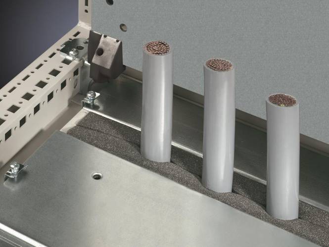 Eine Nahaufnahme von drei zylindrischen Objekten mit Kupferdrahtenden, untergebracht in einem grauen schaumstoffgepolsterten Metallgehäuse.