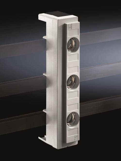 Eine hohe, metallische Struktur mit vier runden Öffnungen auf ihrer Oberfläche, vor einem dunklen Hintergrund mit horizontalen Lichtstreifen.