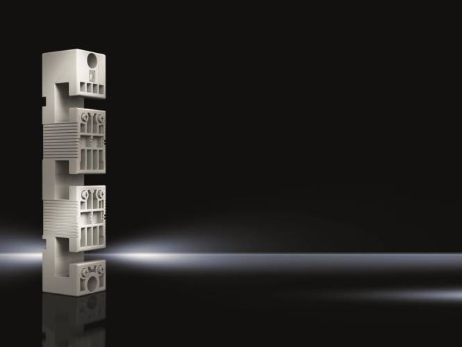 Ein Stapel von Architekturmodellen vor dunklem Hintergrund, die geometrische Muster zeigen und von sanftem Licht von links beleuchtet werden.