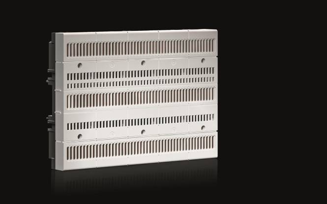 Ein weißes rechteckiges Objekt mit mehreren parallelen Schlitzen und mehreren kreisförmigen Vertiefungen, vor schwarzem Hintergrund.
