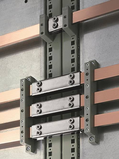 Kupferschienen und eine Komponente eines elektrischen Systems mit Metallverbindern sind an einer Wand montiert und deuten auf eine industrielle elektrische Infrastruktur hin.