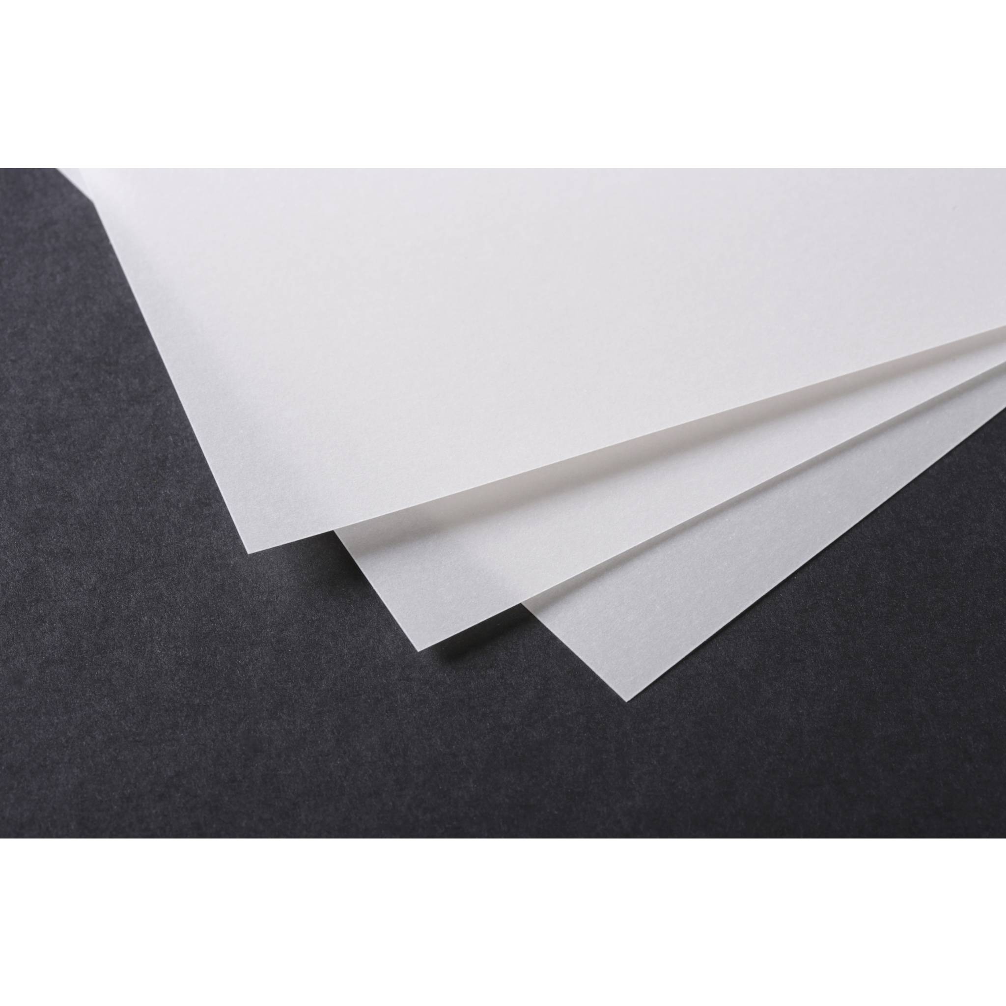 Drei weiße Blätter Papier, diagonal gefächert auf dunkelgrauem Hintergrund.