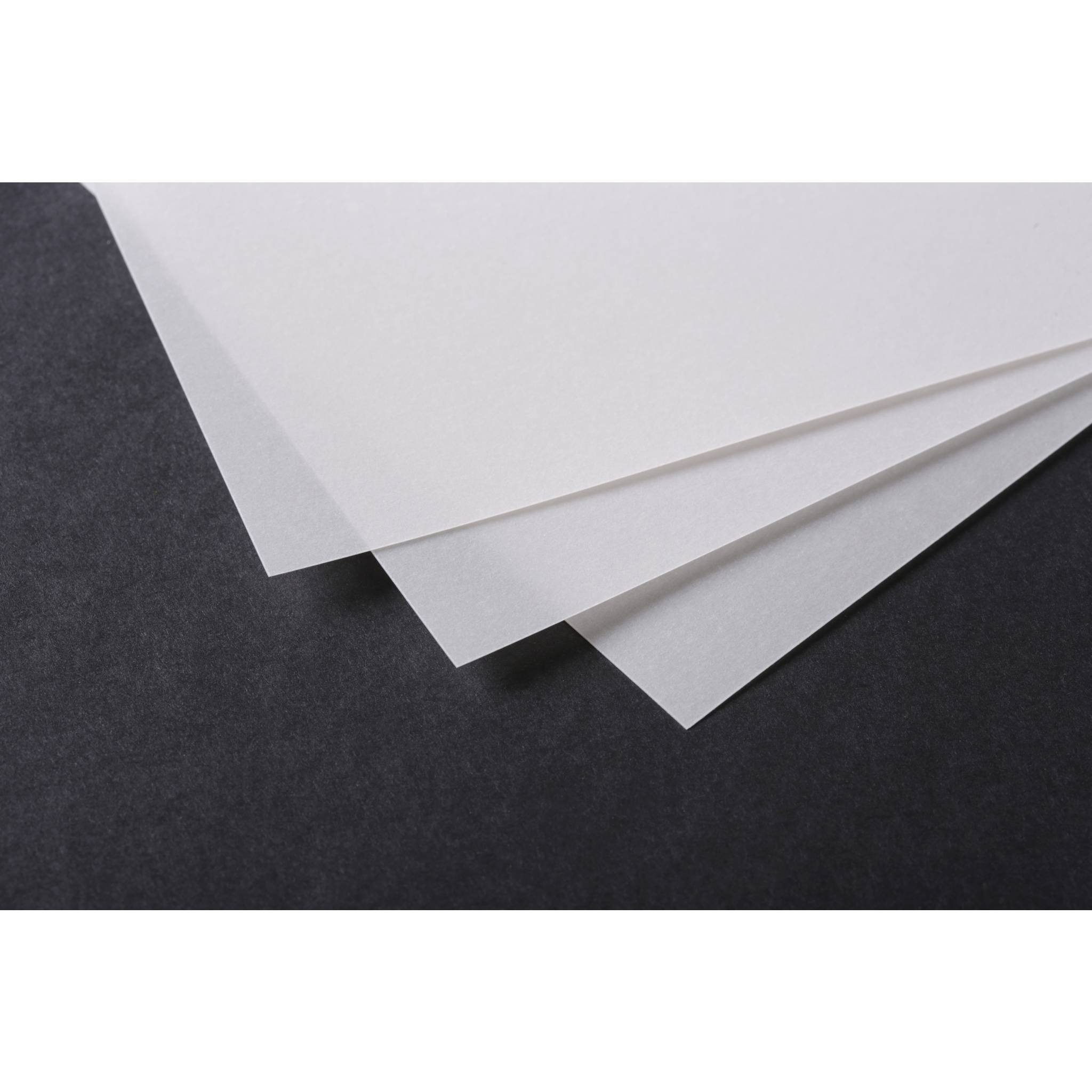 Drei überlappende weiße Blätter Papier auf einer dunklen strukturierten Oberfläche, die ihre Kanten und Schatten zeigen.