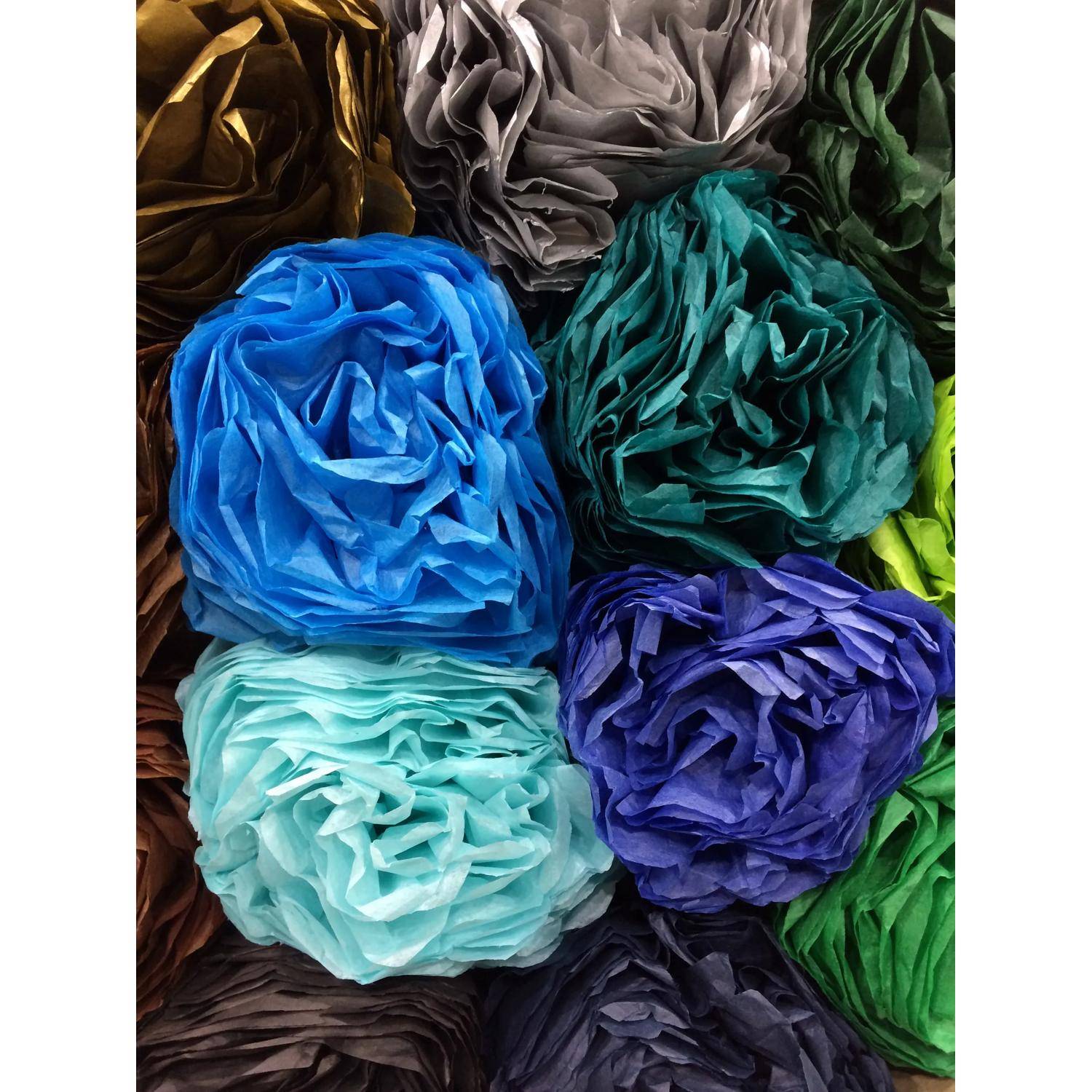 Nahaufnahme von bunten zerknitterten Seidenpapierblüten, die in einem engen Raster angeordnet sind, mit blauen, türkisen, violetten, grauen, grünen, braunen und schwarzen Blüten.