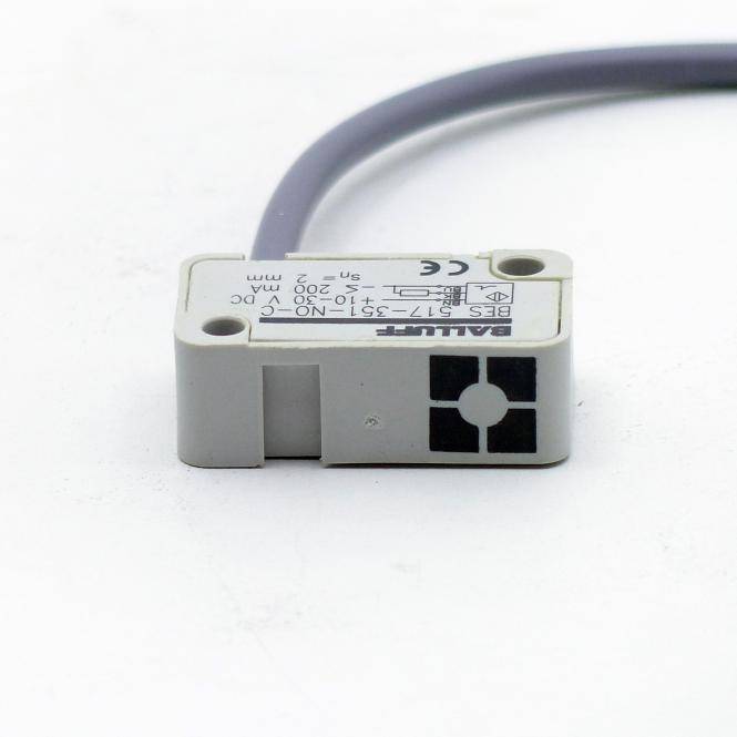 Kompakter grauer Balluff-Sensorsensor mit angebrachtem Kabel, dargestellt auf weißem Hintergrund.