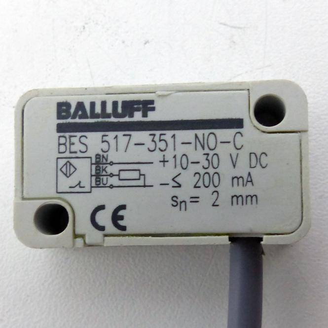 Nahaufnahme eines Balluff BES 517-351-NO-C Industrie-Näherungssensors mit Etikett, das Schaltschema, 10–30 V DC Stromversorgung, 200 mA und 2 mm Erfassungsentfernung zeigt.